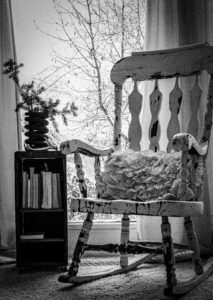 Chipped paint rocking chair with a stack of books.