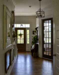 Foyer view of french doors and front door showing the gallery wall to the left.