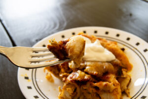 Chicken enchiladas with chopped almonds.