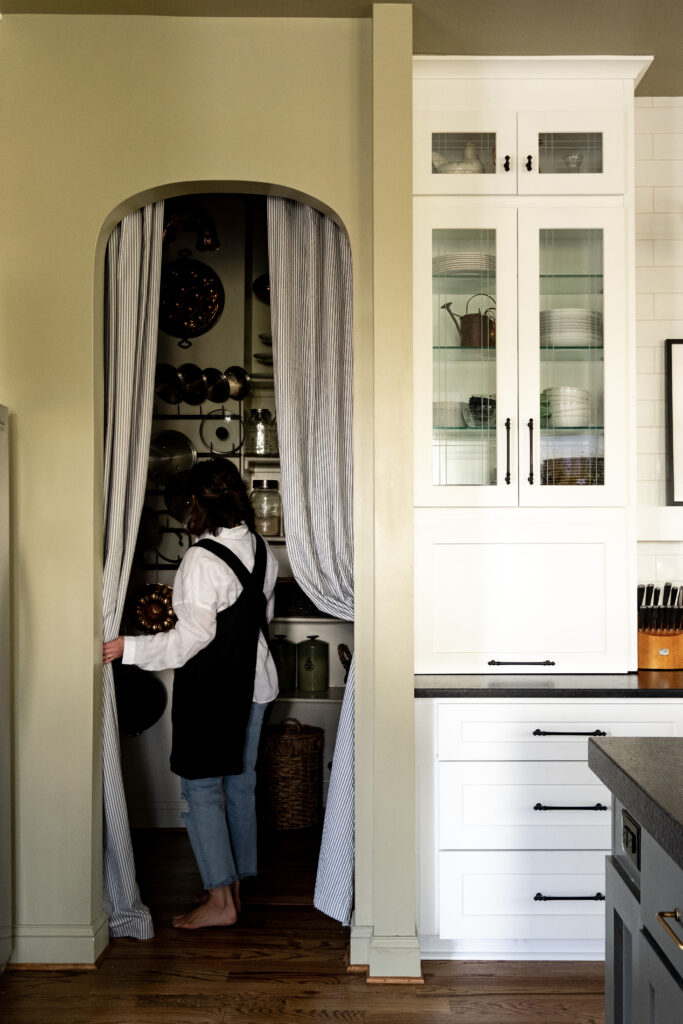 Arched pantry opening without a door but a curtain.