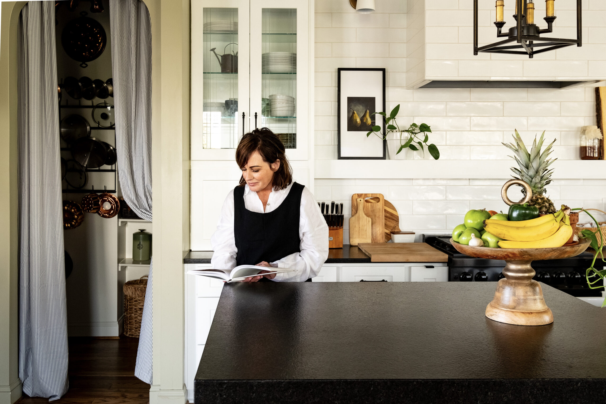 Holly reading recipe book in new white kitchen.